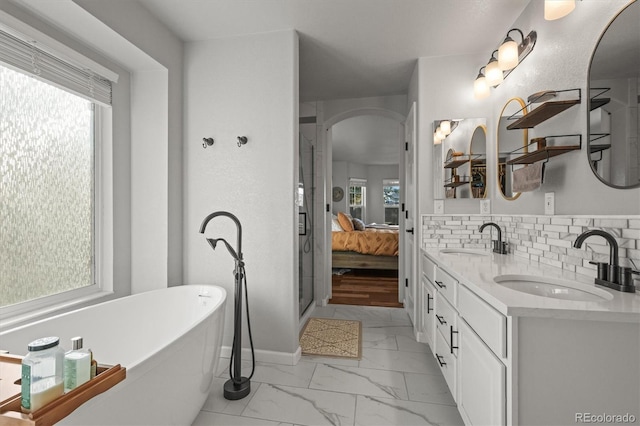 ensuite bathroom featuring marble finish floor, a sink, decorative backsplash, and ensuite bathroom