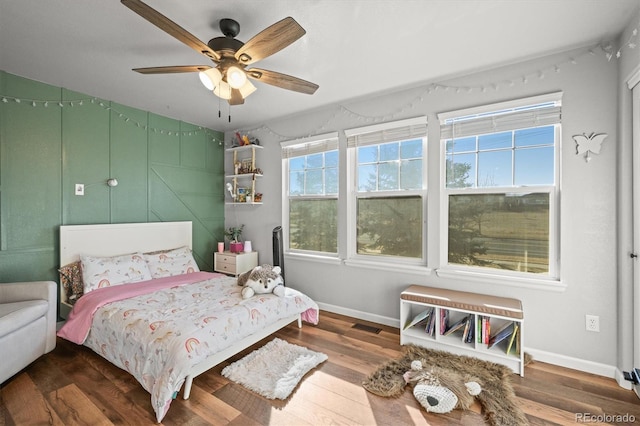 bedroom featuring multiple windows, wood finished floors, visible vents, and baseboards