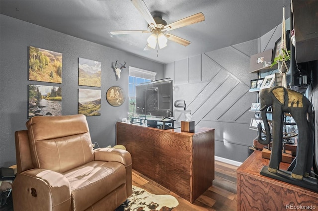 office with ceiling fan, a textured ceiling, wood finished floors, and a textured wall