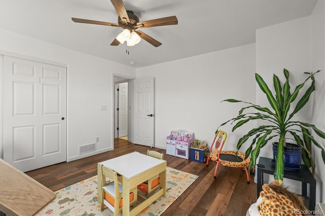 interior space with a ceiling fan, wood finished floors, visible vents, and baseboards