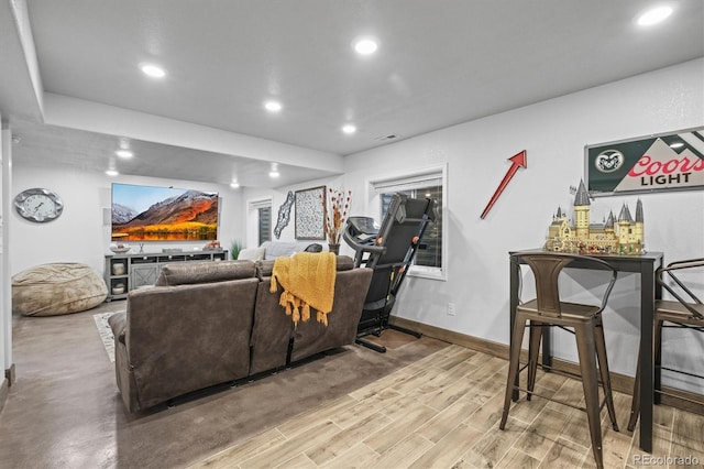 living area featuring a dry bar, visible vents, baseboards, wood finished floors, and recessed lighting