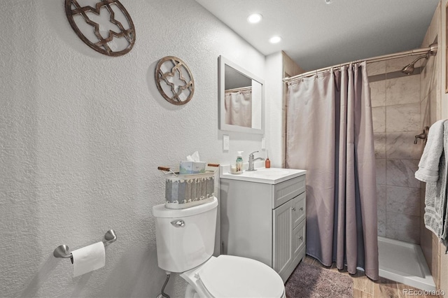 full bathroom with toilet, a tile shower, wood finished floors, and a textured wall