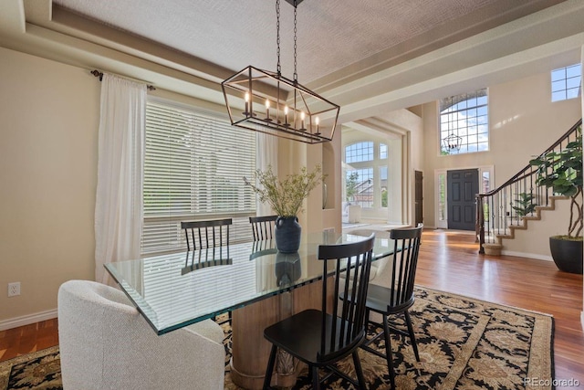 7408 Sodalite Way, Castle Rock, CO 80108 - dining space featuring a chandelier, baseboards, wood finished floors, and stairs