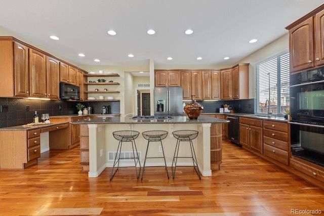 7408 Sodalite Way, Castle Rock, CO 80108 - kitchen featuring black appliances, a sink, open shelves, a breakfast bar area, and a kitchen island