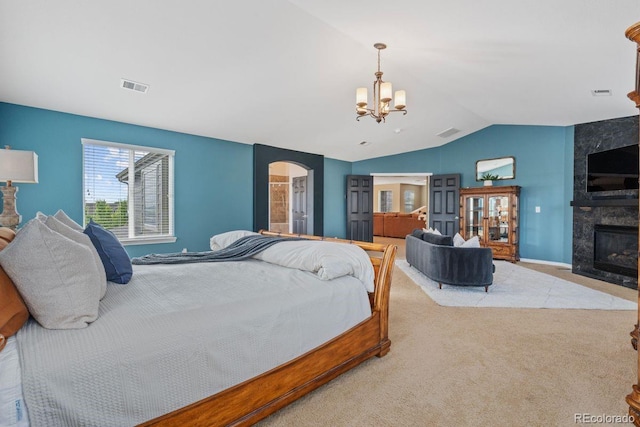 7408 Sodalite Way, Castle Rock, CO 80108 - bedroom with a chandelier, lofted ceiling, arched walkways, a tile fireplace, and carpet