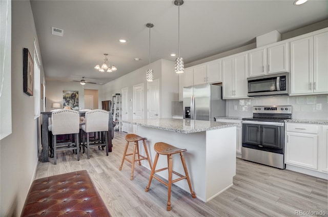 kitchen featuring visible vents, appliances with stainless steel finishes, light wood-type flooring, and decorative backsplash