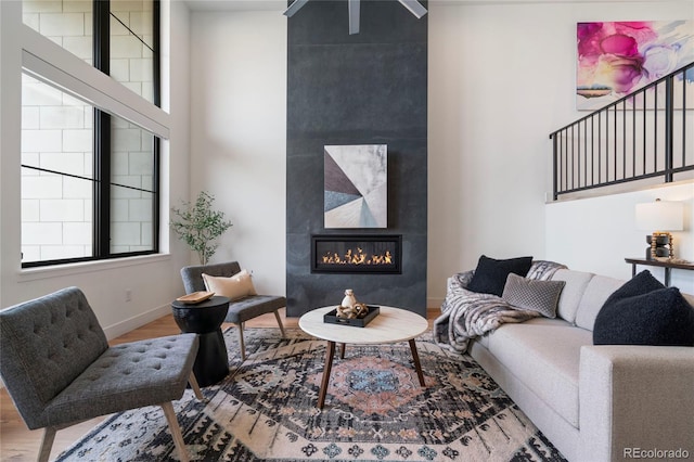 living area featuring baseboards, wood finished floors, and a fireplace