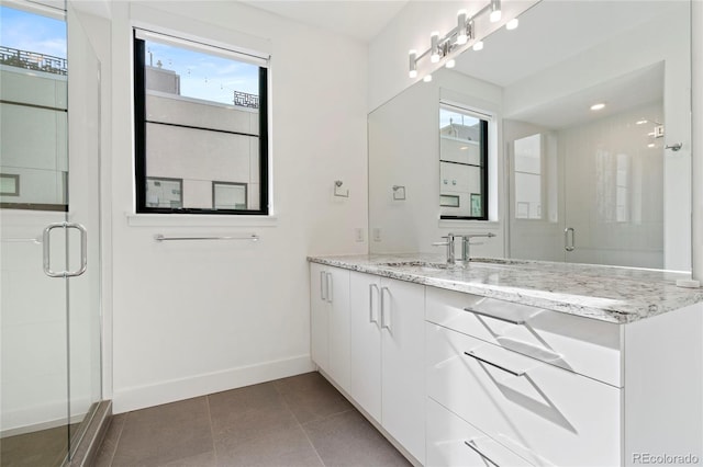 bathroom with baseboards, tile patterned flooring, vanity, and a shower stall
