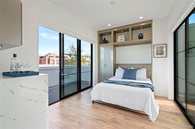 bedroom featuring recessed lighting, access to exterior, multiple windows, and light wood-style floors