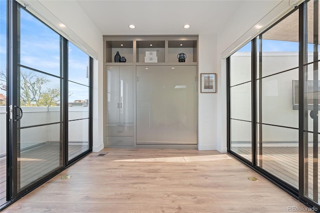 doorway to outside featuring recessed lighting and light wood finished floors