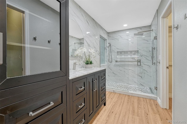 123 Wheat Ridge St, Palmer Lake, CO 80133 - bathroom with a marble finish shower, vanity, wood finished floors, and recessed lighting