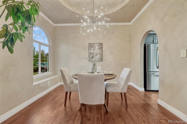 123 Wheat Ridge St, Palmer Lake, CO 80133 - dining area with hardwood / wood-style flooring, arched walkways, a chandelier, and crown molding