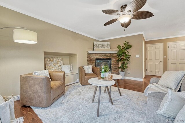 123 Wheat Ridge St, Palmer Lake, CO 80133 - living area with wood finished floors, ceiling fan, crown molding, and a stone fireplace
