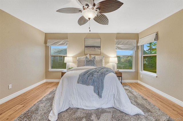 123 Wheat Ridge St, Palmer Lake, CO 80133 - bedroom with wood finished floors, multiple windows, and ceiling fan