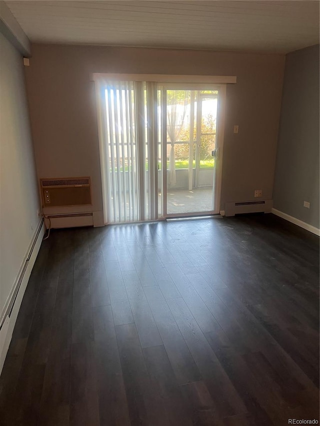 665 S Clinton St Unit 14A, Denver, CO 80247 - empty room featuring a baseboard heating unit, dark wood-style flooring, an AC wall unit, and baseboards