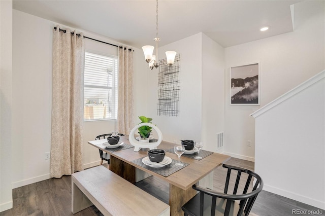 dining room with dark hardwood / wood-style floors and a notable chandelier