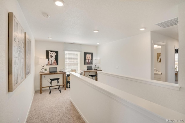 hallway with light colored carpet