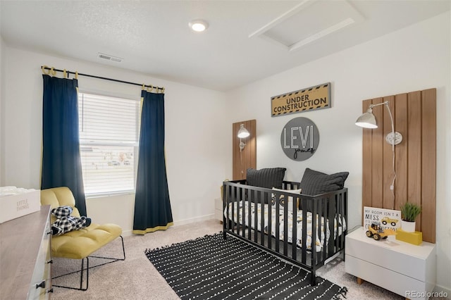 bedroom with a crib and a textured ceiling