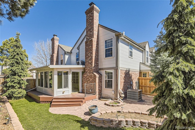 7559 S Ivanhoe Cir, Centennial, CO 80112 - back of property with a wooden deck, a chimney, central AC, a patio area, and a sunroom