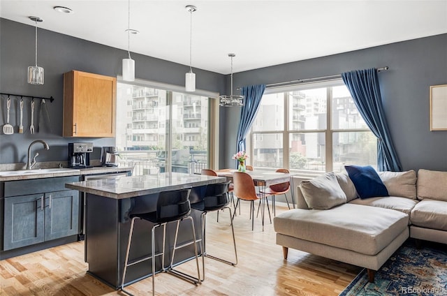 1440 Little Raven St Unit 202, Denver, CO 80202 - kitchen featuring a sink, light wood-style floors, open floor plan, and a kitchen island