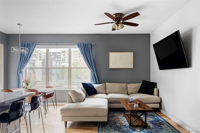 1440 Little Raven St Unit 202, Denver, CO 80202 - living room featuring baseboards, ceiling fan, light wood finished floors, and a chandelier
