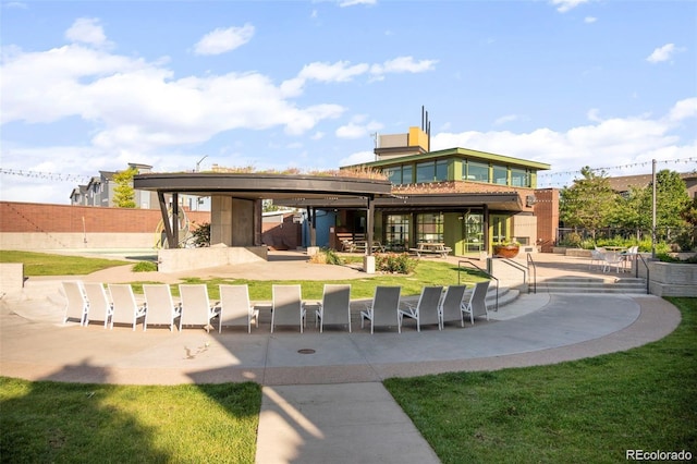 back of property featuring a lawn and a patio