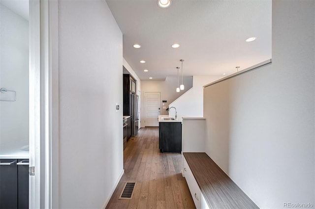 corridor featuring sink and hardwood / wood-style floors