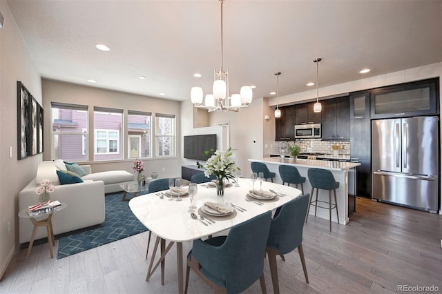 dining space with light wood-type flooring and a chandelier