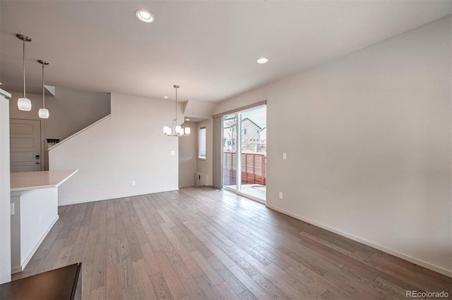 unfurnished living room featuring light hardwood / wood-style floors and an inviting chandelier