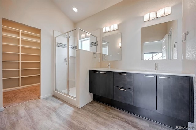 bathroom featuring hardwood / wood-style flooring, built in features, an enclosed shower, and vanity