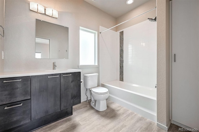 full bathroom with  shower combination, toilet, hardwood / wood-style floors, and vanity