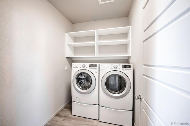 washroom with separate washer and dryer and light wood-type flooring