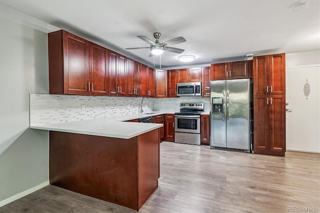 595 S Alton Way Unit 7B, Denver, CO 80247 - kitchen with appliances with stainless steel finishes, a ceiling fan, decorative backsplash, a peninsula, and light wood-style flooring