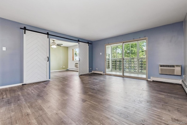 595 S Alton Way Unit 7B, Denver, CO 80247 - unfurnished living room featuring a barn door, a wall mounted air conditioner, wood finished floors, and a baseboard radiator