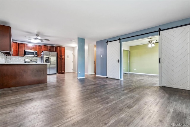 595 S Alton Way Unit 7B, Denver, CO 80247 - unfurnished living room featuring a barn door, dark wood finished floors, and ceiling fan