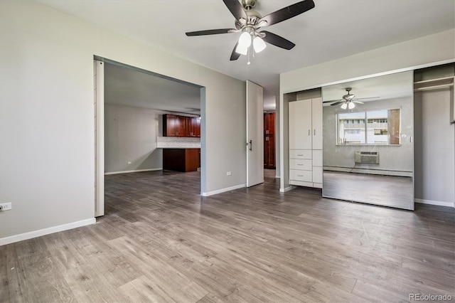 595 S Alton Way Unit 7B, Denver, CO 80247 - unfurnished living room featuring an AC wall unit, a ceiling fan, wood finished floors, and baseboard heating
