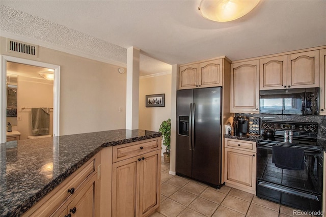 kitchen with dark stone counters, a textured ceiling, light tile patterned flooring, black appliances, and light brown cabinets