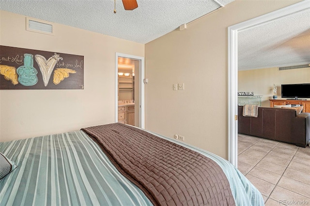 bedroom with light tile patterned floors, a textured ceiling, and ceiling fan