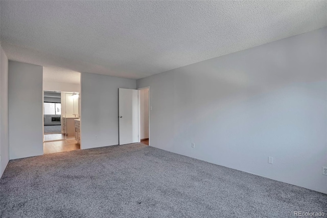 unfurnished bedroom with carpet flooring and a textured ceiling