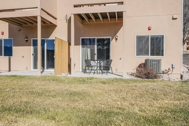 rear view of house with a patio, a balcony, cooling unit, and a yard