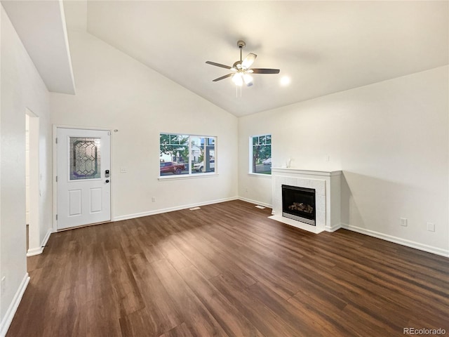 unfurnished living room featuring ceiling fan, a tiled fireplace, dark hardwood / wood-style floors, and high vaulted ceiling