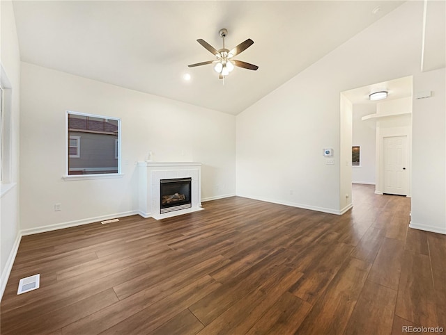 unfurnished living room featuring ceiling fan, dark hardwood / wood-style floors, a tiled fireplace, and high vaulted ceiling