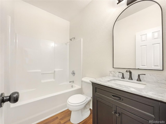 full bathroom featuring toilet, hardwood / wood-style flooring, tub / shower combination, and vanity