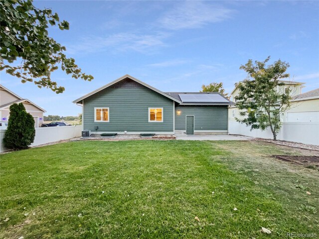 rear view of property with a patio area, a lawn, and central AC