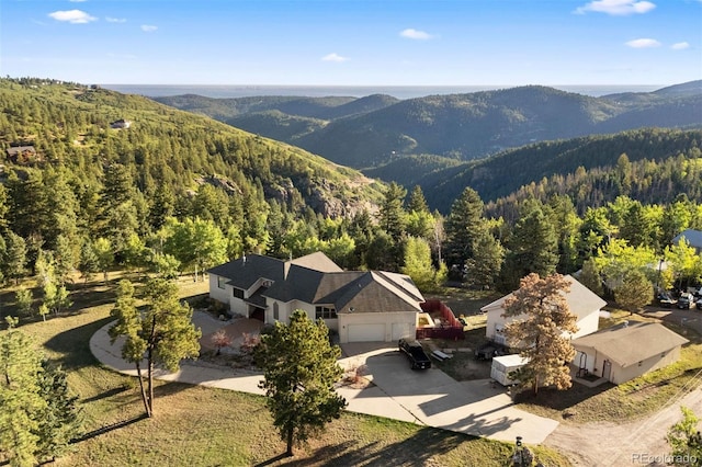 birds eye view of property with a mountain view and a wooded view