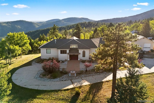 view of front of property with a mountain view and a forest view