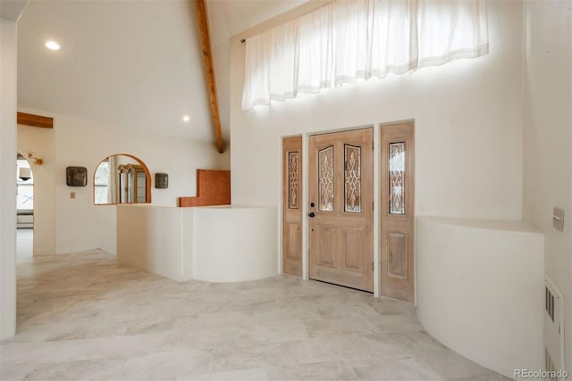 foyer entrance with beam ceiling and high vaulted ceiling