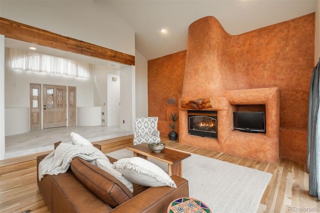 living area featuring recessed lighting, a tile fireplace, high vaulted ceiling, and wood finished floors