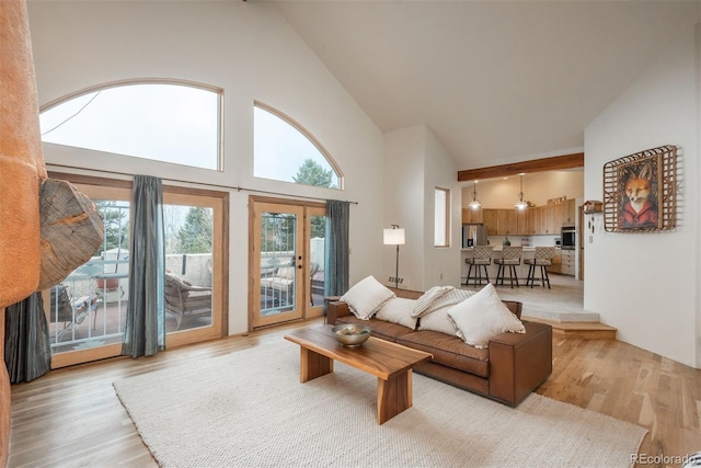 living room featuring light wood finished floors and high vaulted ceiling