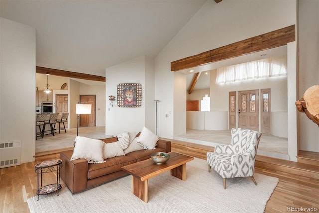 living room featuring beam ceiling, high vaulted ceiling, visible vents, and wood finished floors